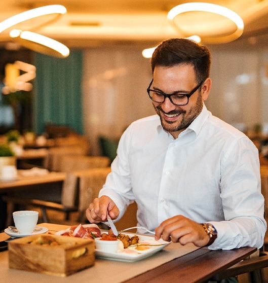 Man smiling while enjoying meal at restaurant