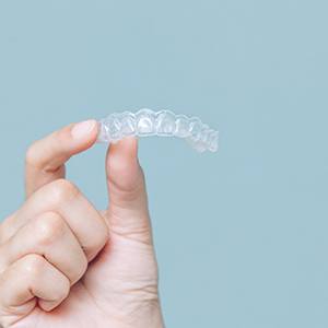 Closeup of patient holding clear aligner