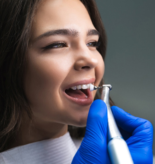 Patients smiling while tooth-colored filling is being polished 