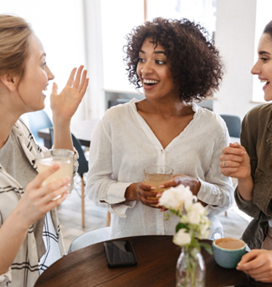 Rowlett patient having coffee with friends after getting tooth-colored filling