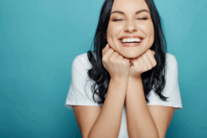 Woman with perfectly straight teeth smiling on blue background