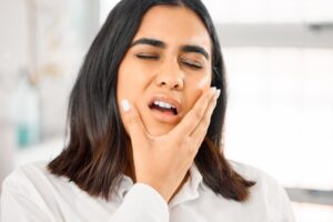 Woman holding mouth in pain. 